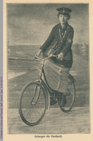Postbotin in Uniform auf Fahrrad